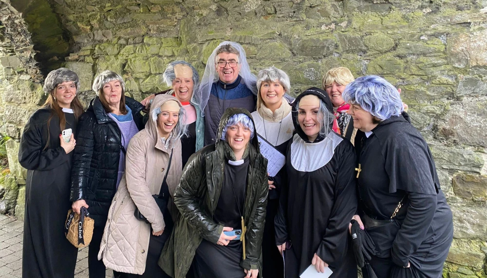 Hen party group in costumes at stone ruins during a Finding Ted game