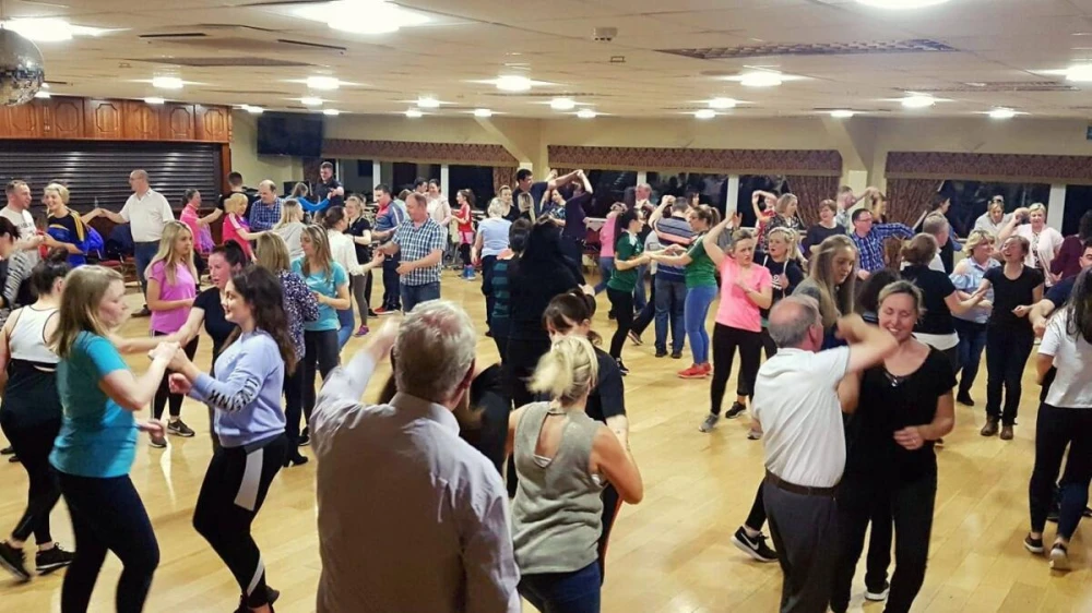 Packed dance hall with people jive dancing