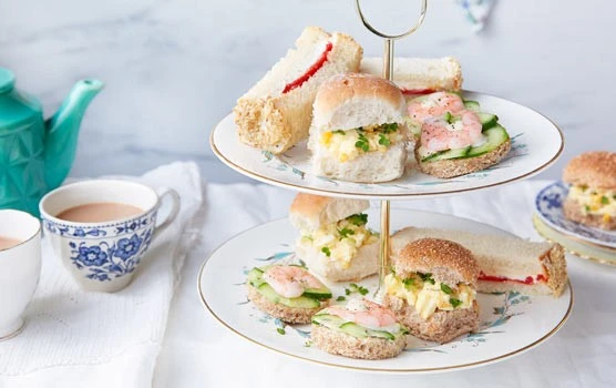 Elegant tiered afternoon tea with sandwiches and cakes