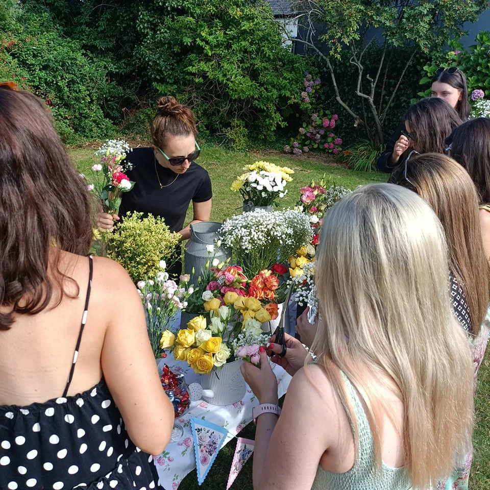 Women making flower crowns outdoors at a workshop in Carlingford