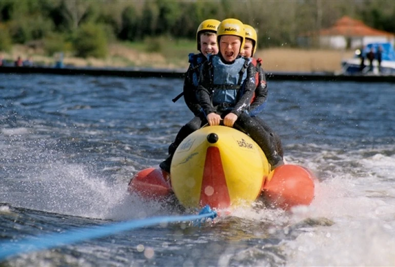 Two people on a banana boat bouncing through the water