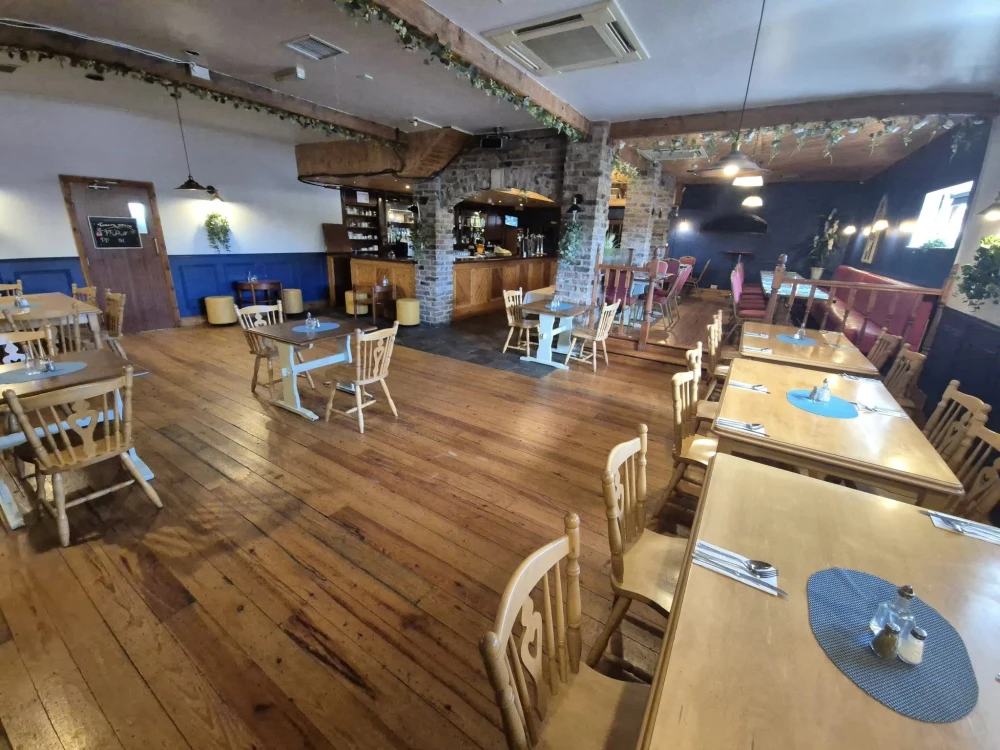 Cosy rustic restaurant interior with wooden floors and stone bar