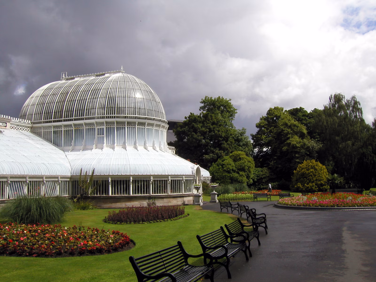 Wide open grounds of Belfast Botanic Gardens in summer, with the museum building visible in the background