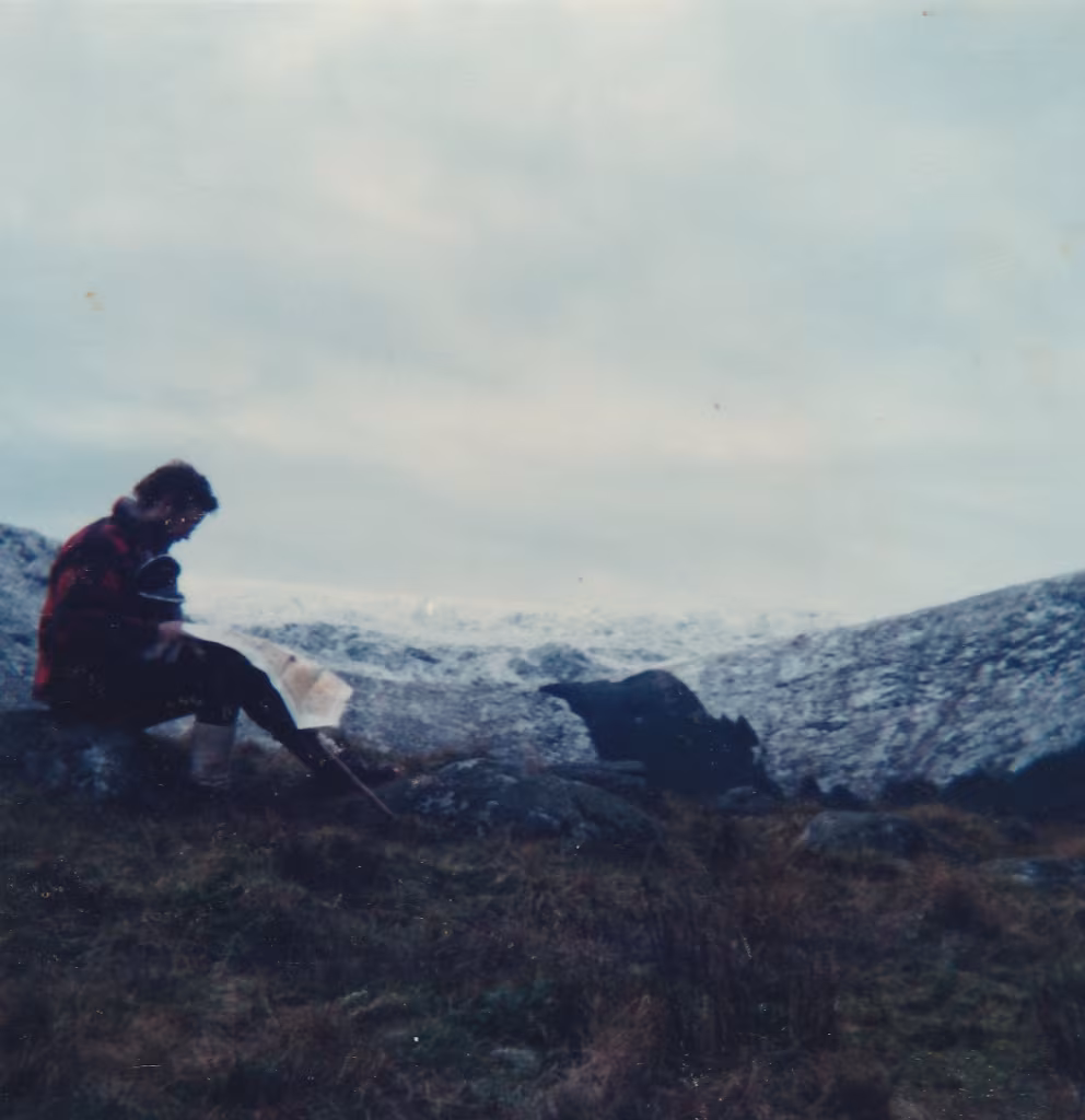 Walkers looking out over the Glenmalure valley from the eastern hillside in County Wicklow, the valley floor visible below