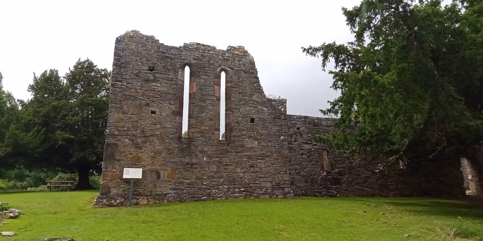 Stone ruins of Innisfallen Abbey on the island, arched doorway intact, stonework covered in moss and ivy