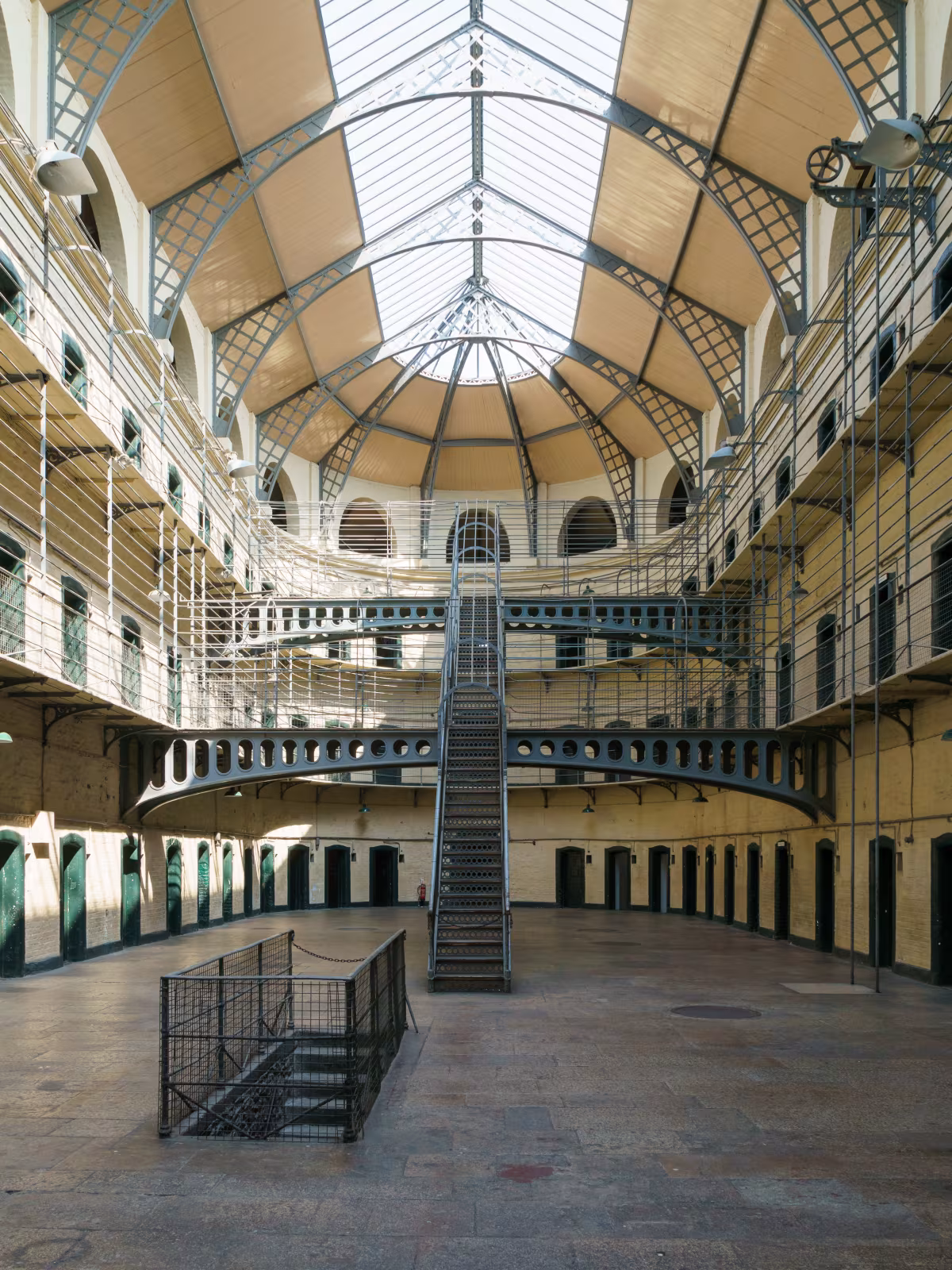 Inside Kilmainham Gaol showing the iron walkways and rows of cell doors along multiple levels