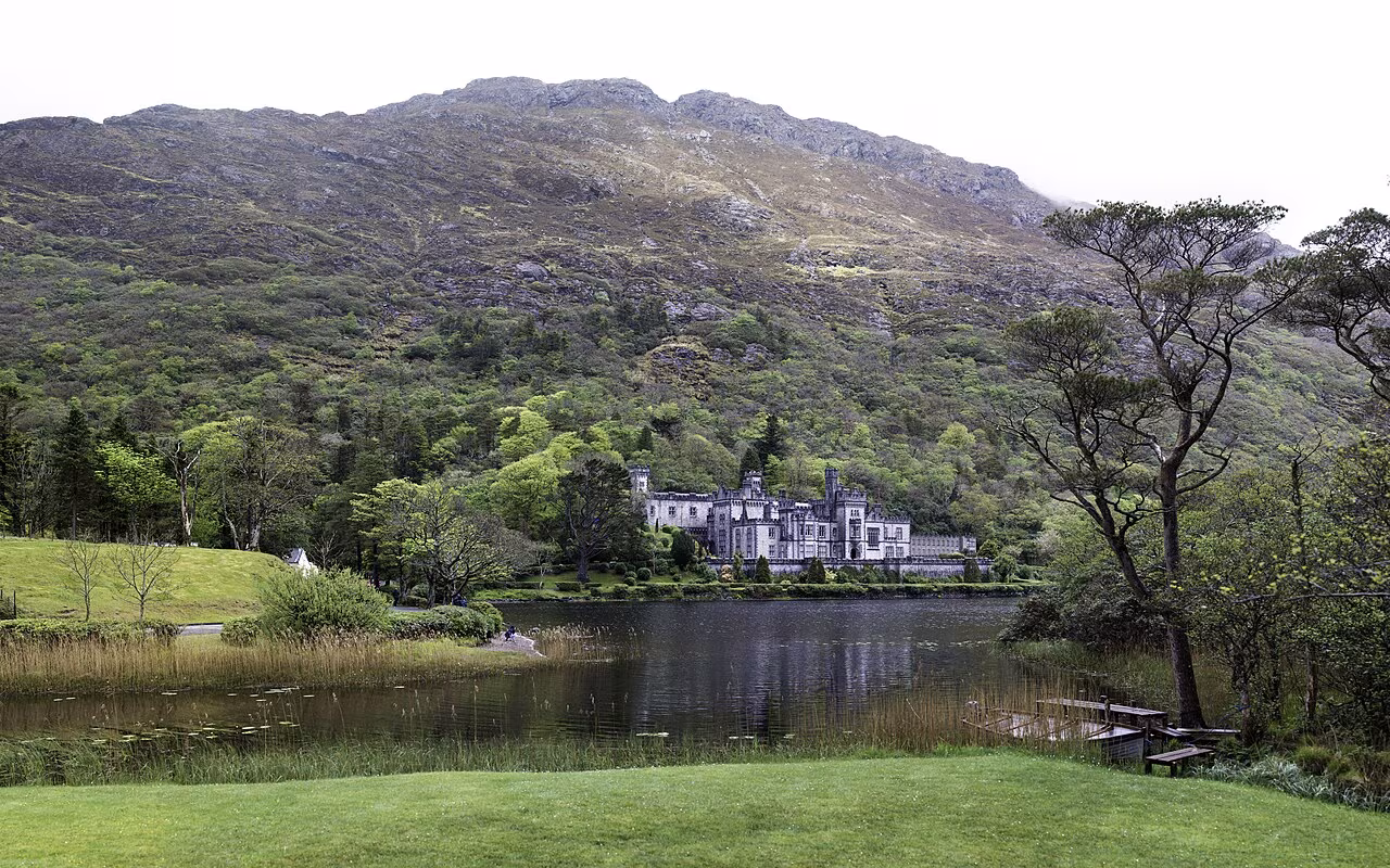 Kylemore Abbey reflected in the still waters of Pollacapall Lough with the Twelve Bens mountain range behind