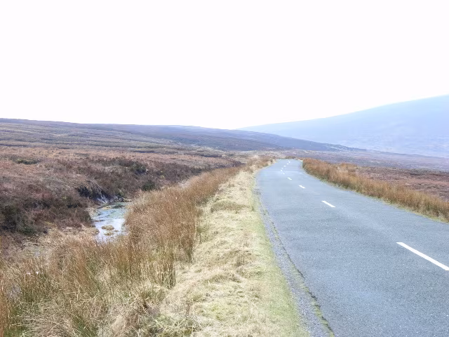 The narrow R115 Military Road crossing open mountain bog north of Sally Gap in County Wicklow