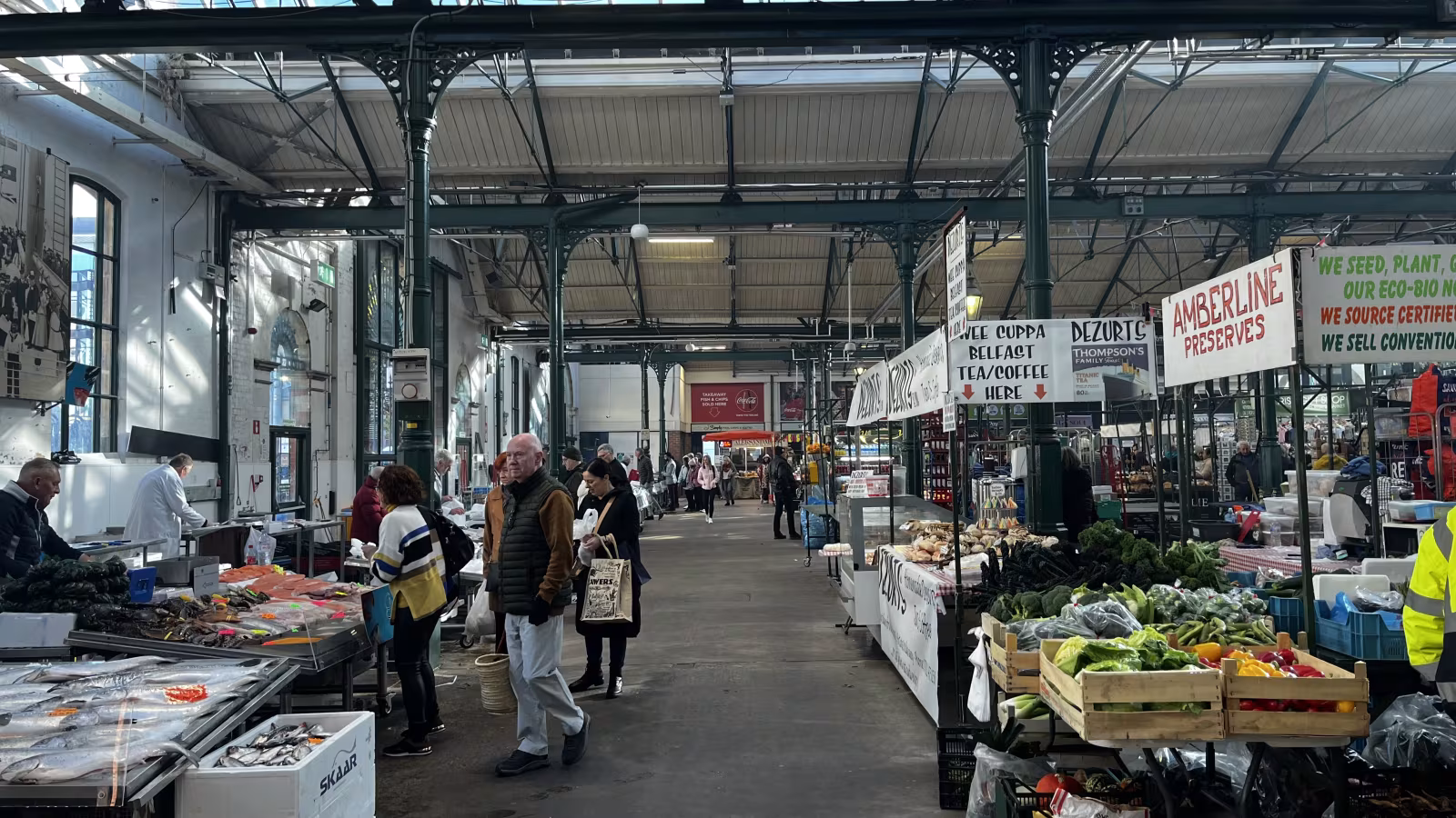 Busy market stalls inside St George's Market Belfast on a weekend morning with shoppers browsing